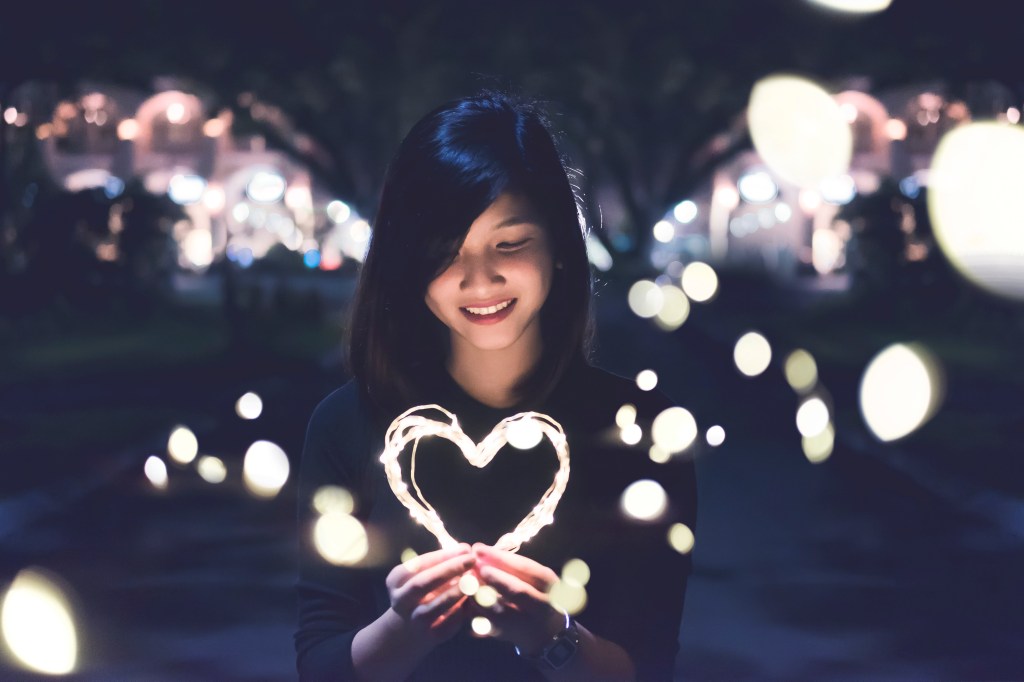 Woman holding heart with lights